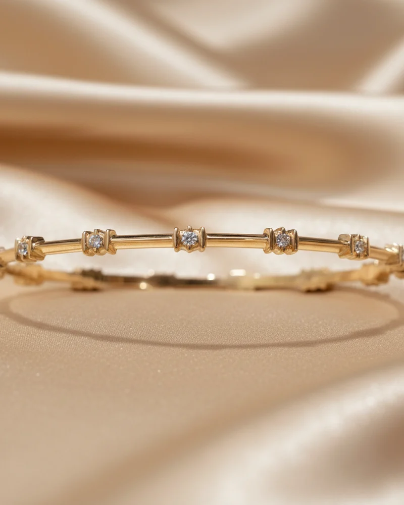 A plain gold bangle with four diamond stations spaced around it.