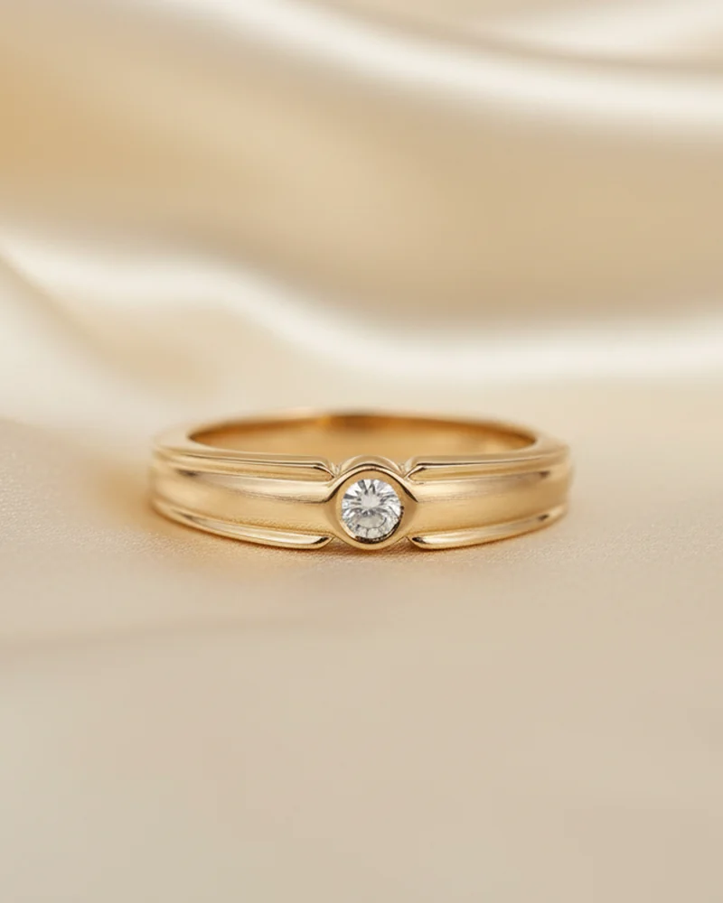 A plain gold band with one diamond set flush into it.