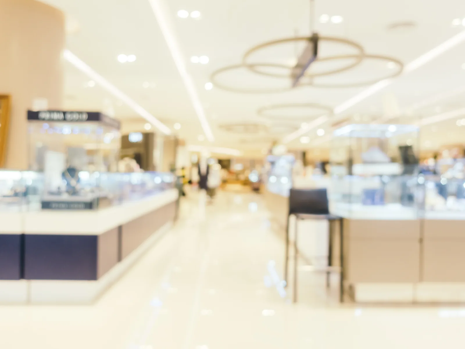 The inside of a jewellery shop, with lit display cases along both sides.